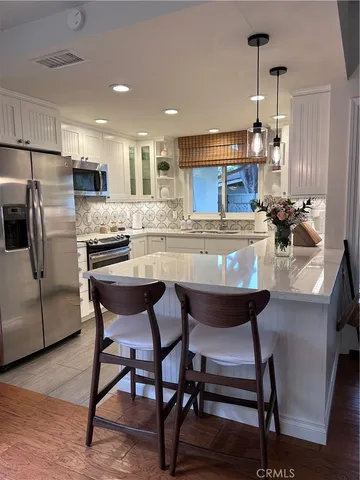 a kitchen with a dining table chairs and refrigerator