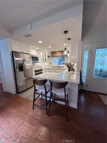 a kitchen with a dining table chairs and refrigerator