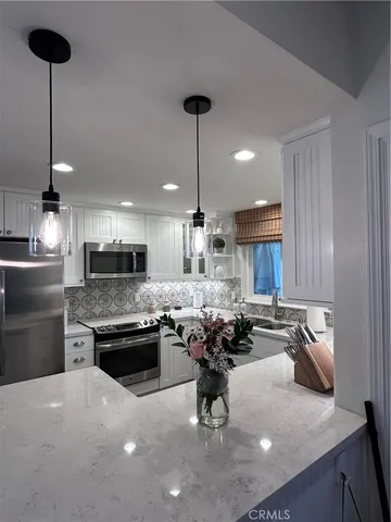 a kitchen with a dining table chairs and a refrigerator