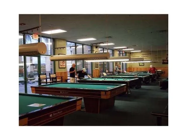 a room with pool table and windows