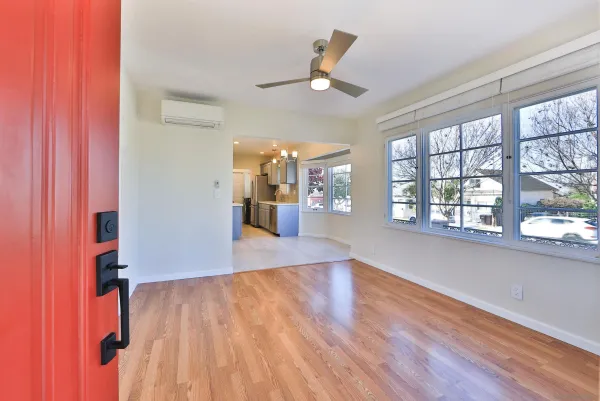 a view of an empty room with a window and wooden floor
