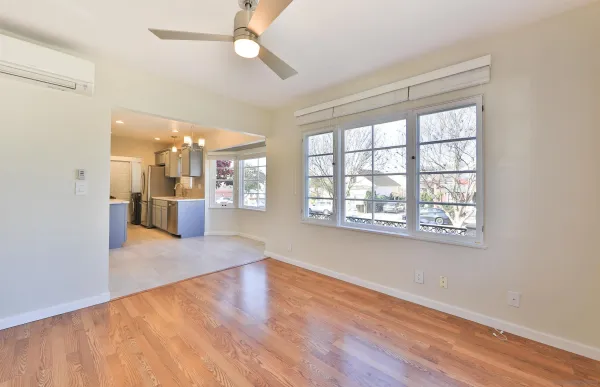 an empty room with wooden floor and windows
