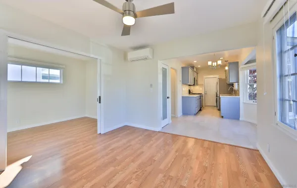 a view of a kitchen with a fridge and wooden floor