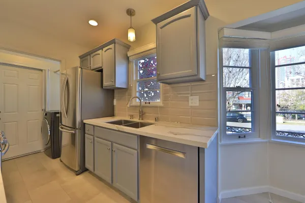 a kitchen with stainless steel appliances granite countertop a sink and a refrigerator