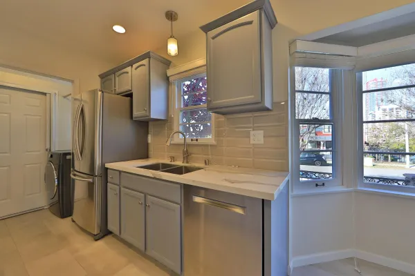 a kitchen with stainless steel appliances granite countertop a sink and a refrigerator