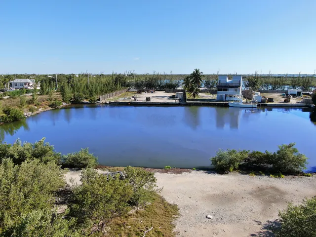 an aerial view of ocean and residential houses with outdoor space
