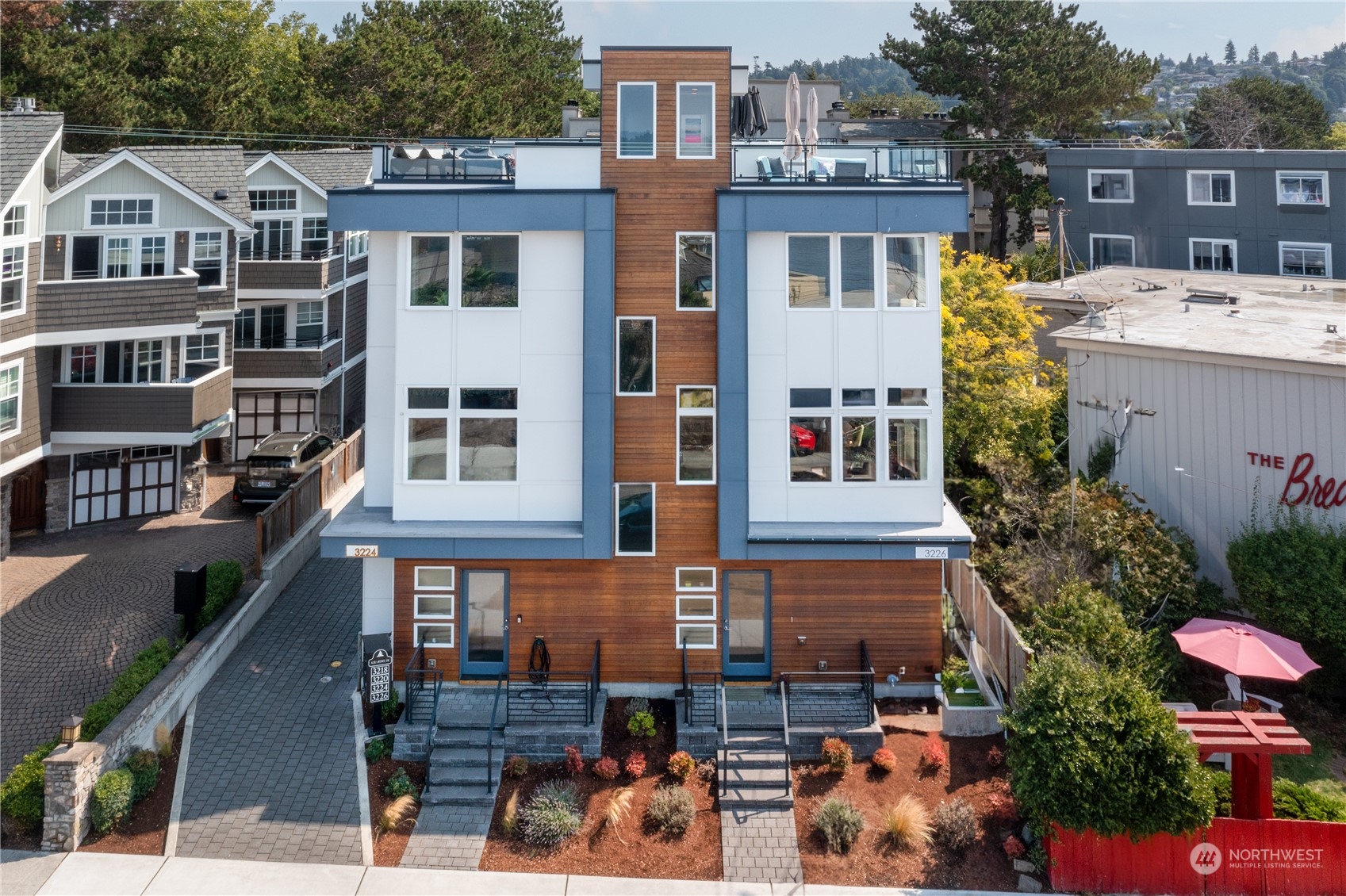 3226 Alki Avenue Southwest Seattle, WA 98116 - Photo 36 of 39 a front view of a residential apartment building with a yard and potted plants