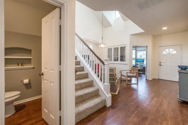 a view of a hallway with wooden floor and entryway