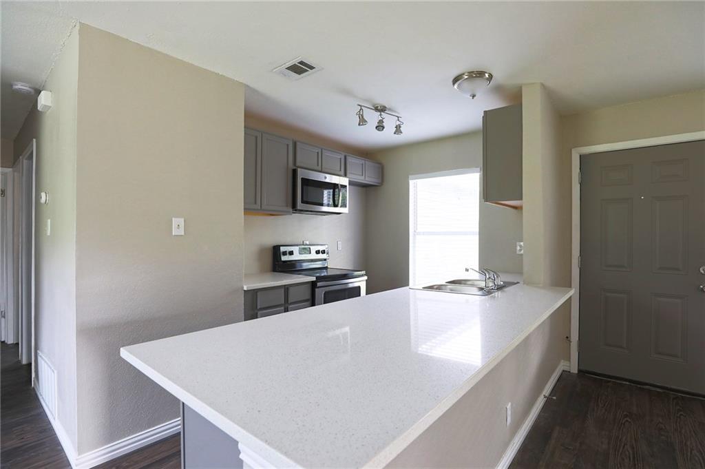 1410 Ransom Street Pflugerville, TX 78660 - Photo 8 of 22 a large white kitchen with sink a refrigerator and a stove top oven
