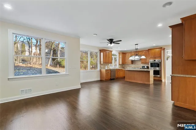 a view of an empty room with a kitchen and a window