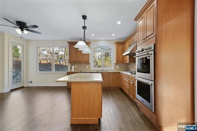 a kitchen with stainless steel appliances granite countertop a sink a stove and a refrigerator