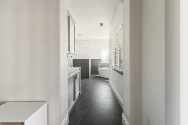 a view of an empty room with wooden floor and windows