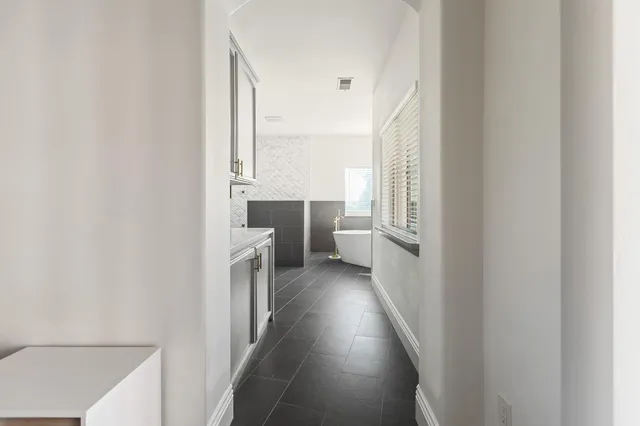 a view of an empty room with wooden floor and windows
