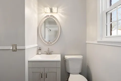 a bathroom with a toilet sink and mirror