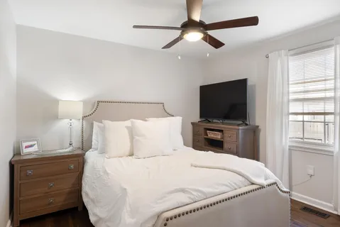 a bedroom with a large bed and a flat tv screen on a dresser