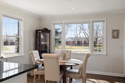 a view of a dining room with furniture large windows and wooden floor