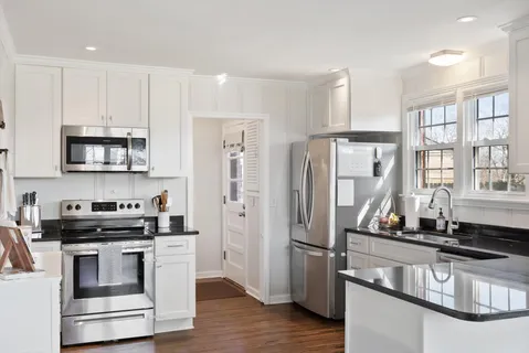 a kitchen with stainless steel appliances a stove a refrigerator and a sink