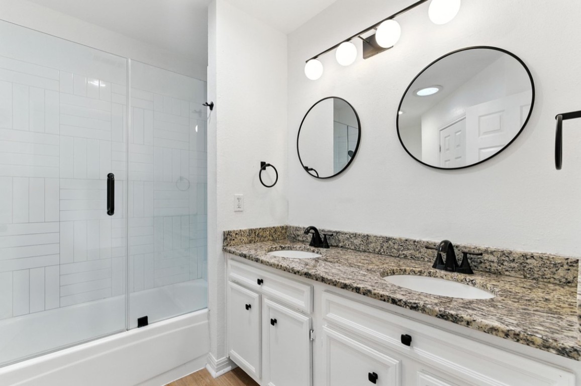 2101 Boxwood Path Round Rock, TX 78664 - Photo 21 of 22 a bathroom with a granite countertop sink a mirror and a shower