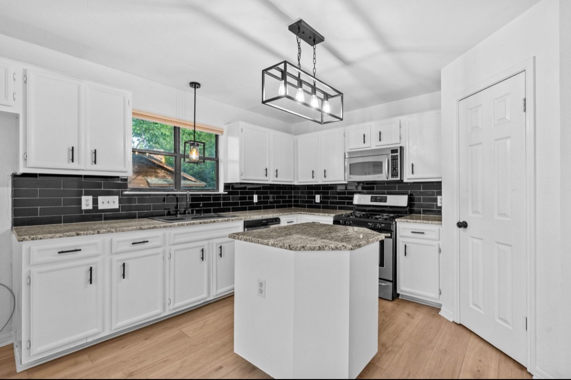 2101 Boxwood Path Round Rock, TX 78664 - Photo 4 of 22 a kitchen with stainless steel appliances granite countertop a sink a stove a refrigerator and cabinets
