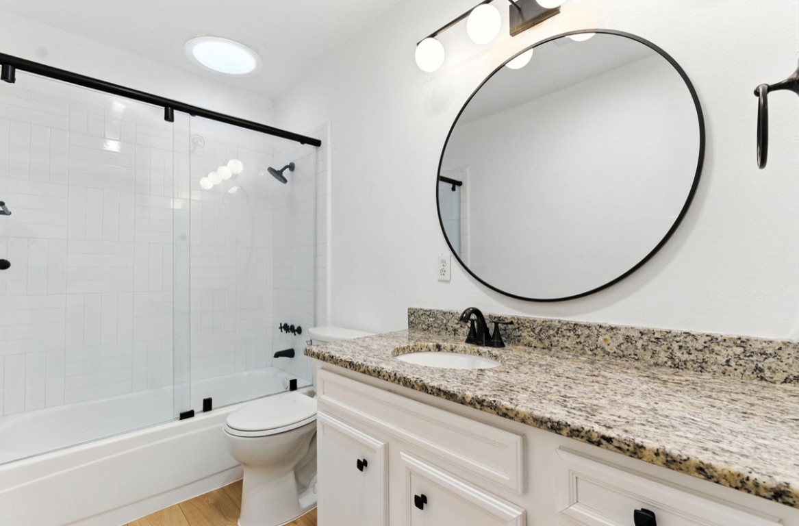 2101 Boxwood Path Round Rock, TX 78664 - Photo 8 of 22 a bathroom with a granite countertop sink a toilet and a mirror