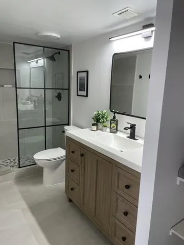 a bathroom with a double vanity sink mirror and toilet