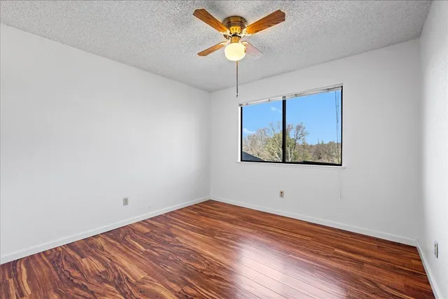 a view of a room with a large window and wooden floor