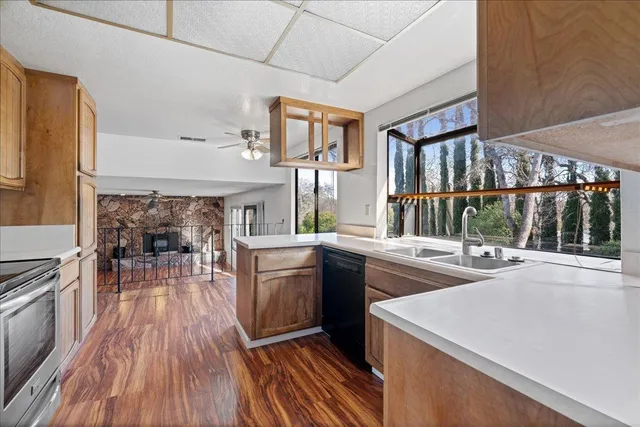 a kitchen with stainless steel appliances granite countertop a stove and a wooden floors