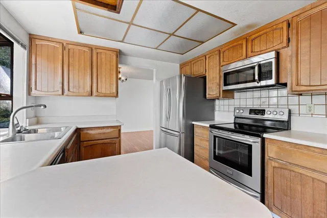 a kitchen with stainless steel appliances granite countertop a sink stove microwave and refrigerator