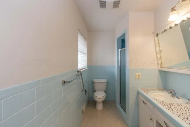 a bathroom with a granite countertop sink a toilet and shower