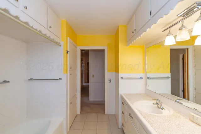 a bathroom with a tub sink and mirror