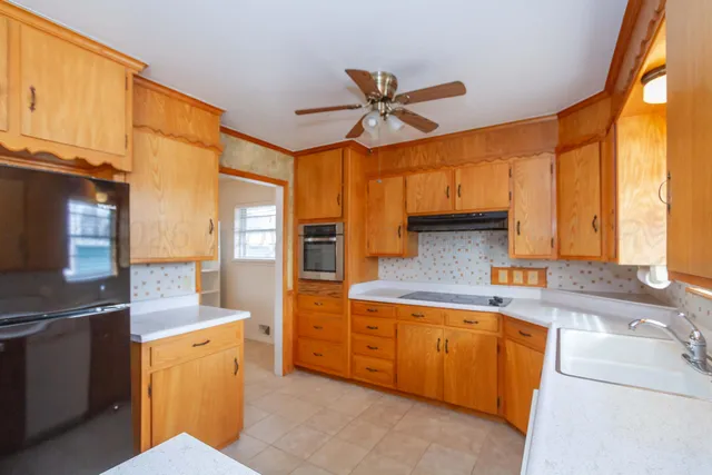 a kitchen with stainless steel appliances granite countertop a sink a stove and a refrigerator