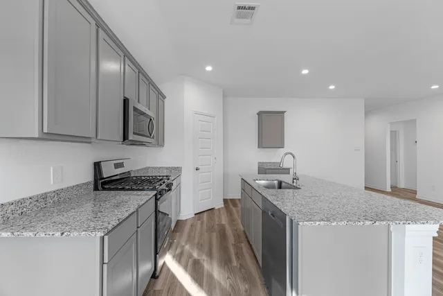 a kitchen with stainless steel appliances granite countertop a sink stove and refrigerator