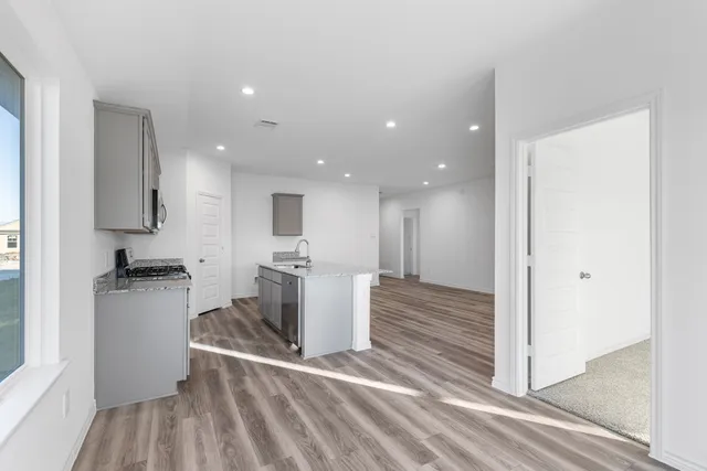 a view of a kitchen with a sink dishwasher stove and cabinets