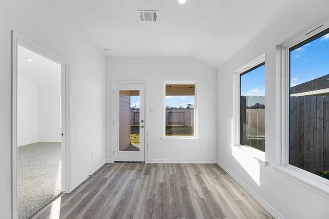 a view of an empty room with glass door and balcony