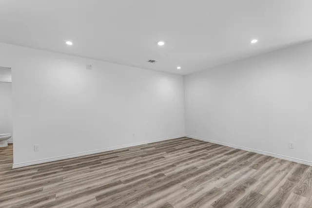 a view of room with wooden floor and white walls