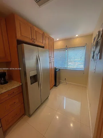 a kitchen with granite countertop a refrigerator and a sink
