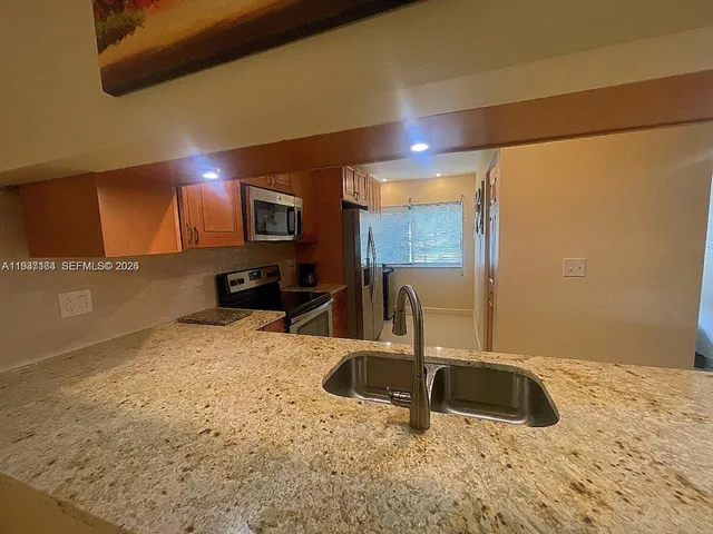 a kitchen with granite countertop a sink and a stove top oven