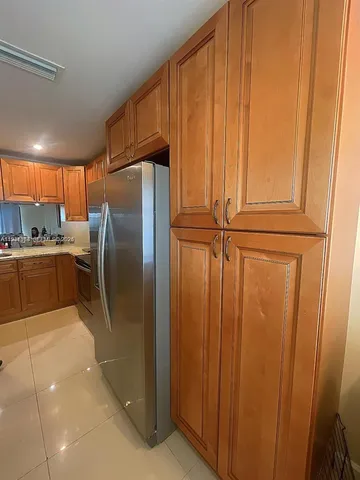 a kitchen with stainless steel appliances granite countertop a refrigerator a sink and cabinets