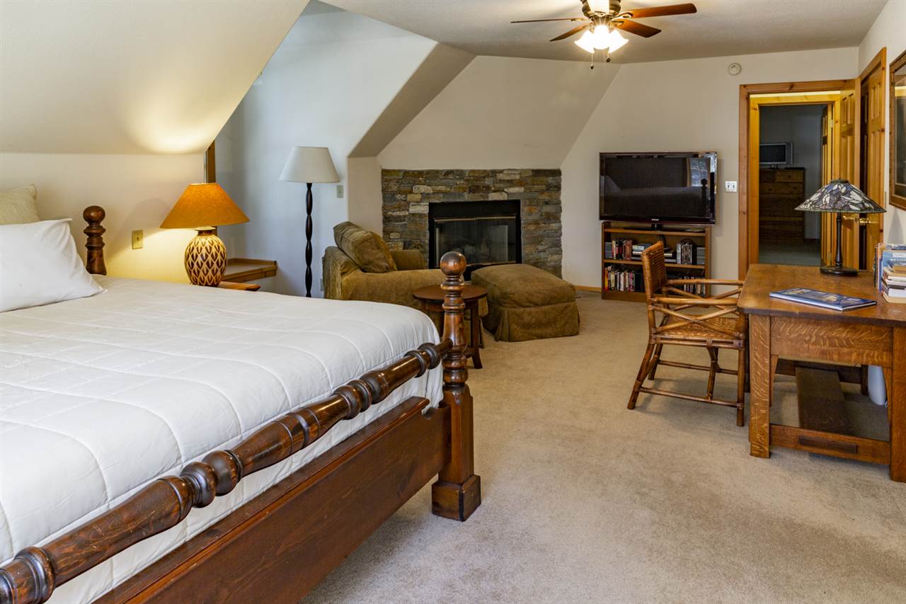12051 Oslo Drive Truckee, CA 96161 - Photo 16 of 21 a spacious bedroom with a bed and a fireplace