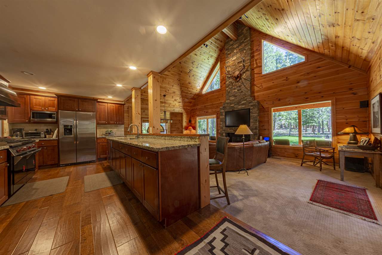 12051 Oslo Drive Truckee, CA 96161 - Photo 6 of 21 a kitchen with refrigerator a stove and a dining table with wooden floor