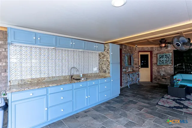 a spacious bathroom with a granite countertop sink and a mirror