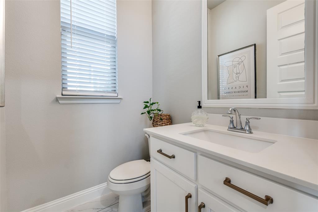 8977 George Cayley Lane Frisco, TX 75034 - Photo 13 of 24 Downstairs bathroom is light and bright and flows with the aesthetic of the home