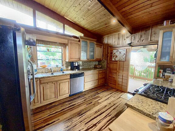 136 Palermo Drive Islamorada, FL 33036 - Photo 17 of 38 a kitchen with stainless steel appliances a stove a refrigerator and wooden cabinets
