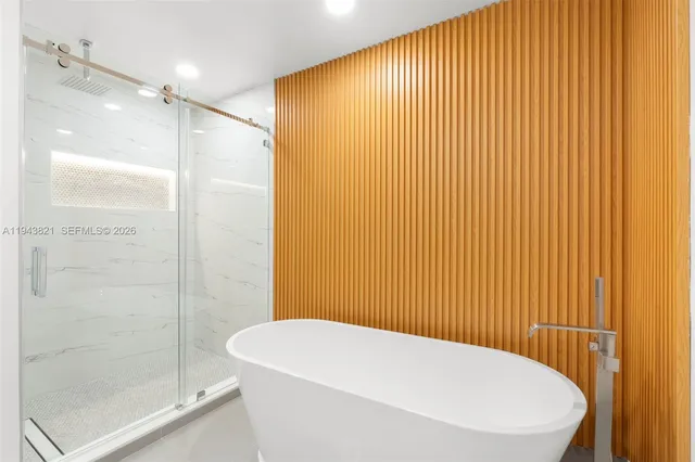 an empty room with wooden floor closet and windows