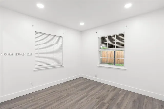 an empty room with a cabinet and mirrors