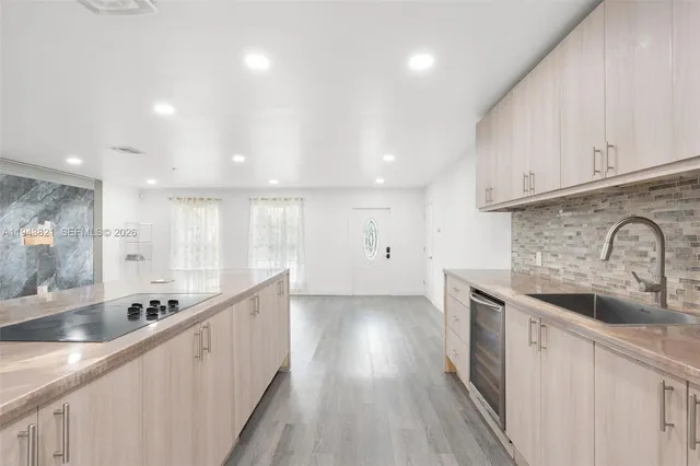a large kitchen with stainless steel appliances granite countertop a lot of counter space and wooden floors