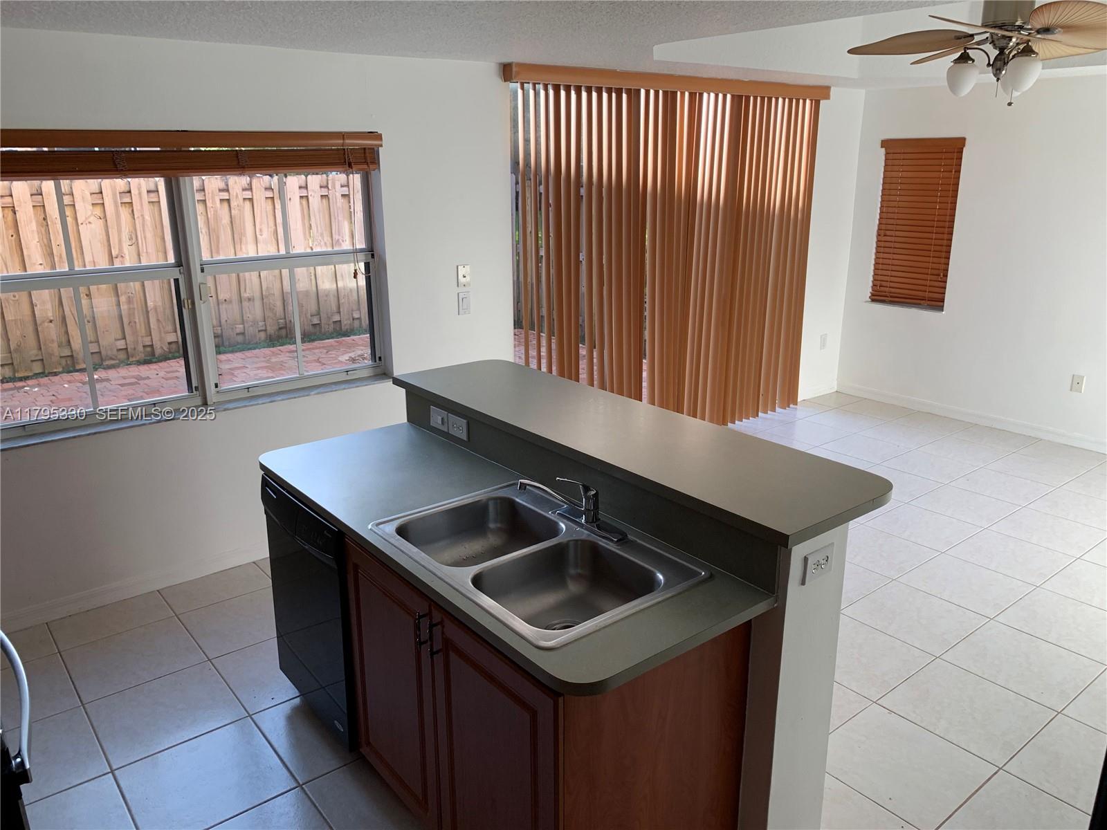 3150 Southwest 152nd Place Miami, FL 33185 - Photo 25 of 47 a kitchen with a sink a stove and a microwave