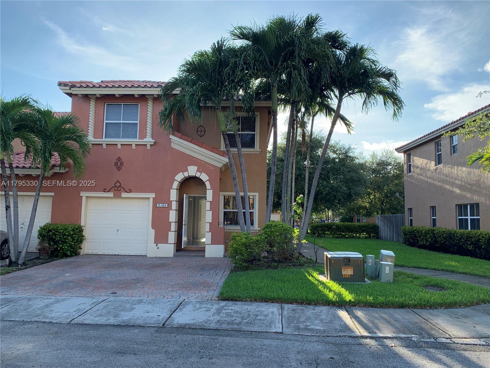 3150 Southwest 152nd Place Miami, FL 33185 - Photo 7 of 47 a front view of a house with a yard and a garage