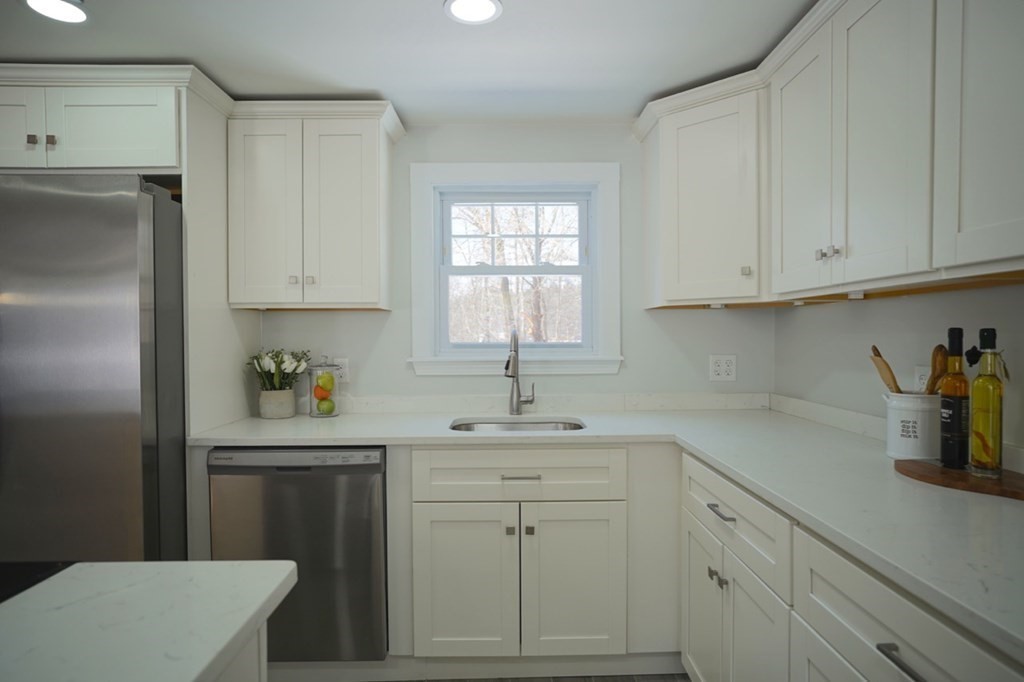 28 Chamberlain Road Chelmsford, MA 01824 - Photo 11 of 38 a kitchen with white cabinets and white appliances