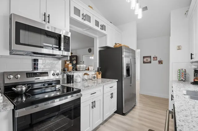 a kitchen with stainless steel appliances a stove a microwave and a refrigerator